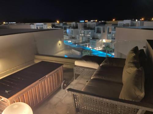 a couch sitting on top of a balcony at night at Gouna Pool view with rooftop living & BBQ grill in Hurghada