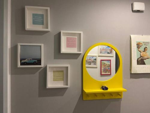 a wall with a yellow mirror and pictures on a wall at Gouna Pool view with rooftop living & BBQ grill in Hurghada