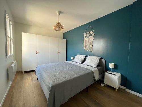 - une chambre bleue avec un lit et un mur bleu dans l'établissement Le Monterelais : Hypercentre, à Montereau-faut-Yonne