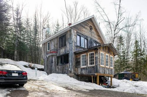una casa que se está construyendo en la nieve en Charming Cottage In a Peaceful Forest & Calm River, en Sainte Béatrix