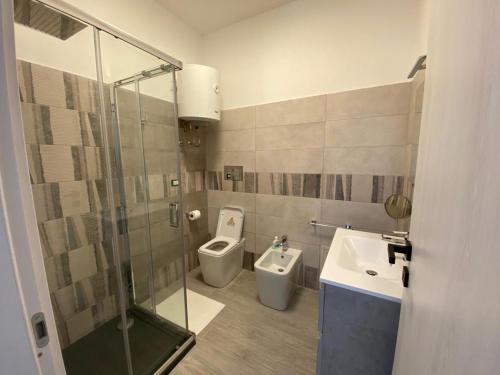 a bathroom with a shower and a toilet and a sink at Casa di Giu' - favignana in Favignana