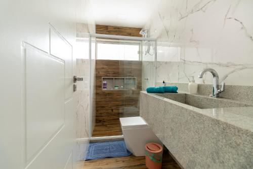 a bathroom with a shower and a sink and a toilet at Casa Na Praia em Angra dos Reis in Angra dos Reis