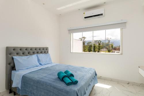 a bedroom with a bed with blue towels on it at Casa Na Praia em Angra dos Reis in Angra dos Reis