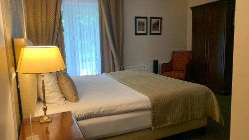 a bedroom with a bed with a lamp and a chair at De Lunterse Boer in Lunteren