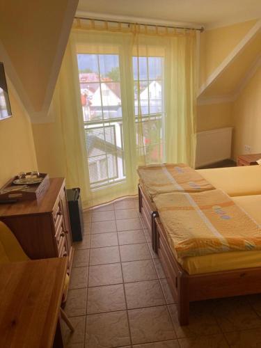 a room with two beds and a desk and a window at Pod Delfinem Rewal in Rewal