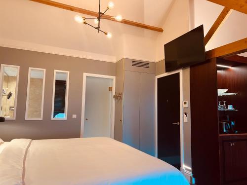 a bedroom with a bed and a flat screen tv at Gatsby Hotel - Adults Only - Small Luxury Hotel - by F-Hotels in Blankenberge