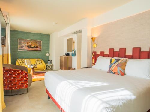 una habitación de hotel con una cama grande y una silla en Hard Rock Hotel Marbella - Puerto Banús Adults Recommended, en Marbella