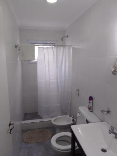 ein weißes Bad mit einem WC und einem Waschbecken in der Unterkunft cel2245508464 Céntrico in Dolores