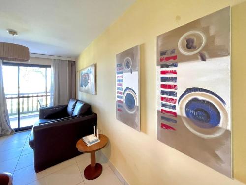 a living room with a couch and posters on the wall at Resort VG SUN por Be My Guest! in Caucaia