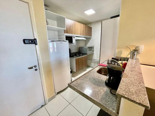 a kitchen with a white refrigerator and a counter top at Resort VG SUN por Be My Guest! in Caucaia