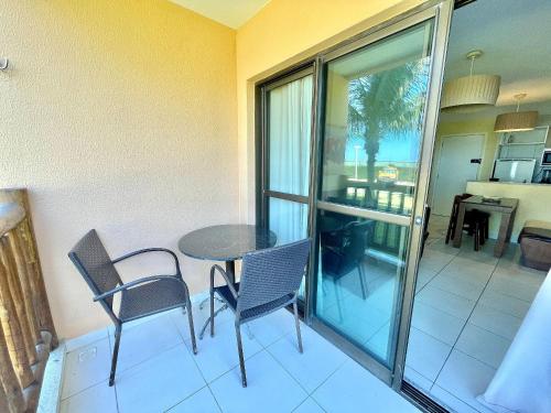 a patio with a table and chairs on a balcony at Resort VG SUN por Be My Guest! in Caucaia