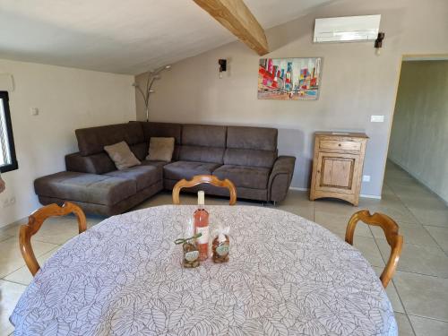 a living room with a table and a couch at Gite de charme La Martinelle in La Bégude-de-Mazenc