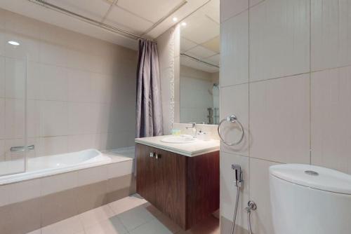 a bathroom with a sink and a tub and a toilet at West Heights 2 - Vacationer in Dubai