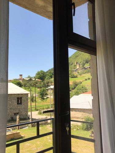 a window with a view of a field outside at Ninama in Mestia