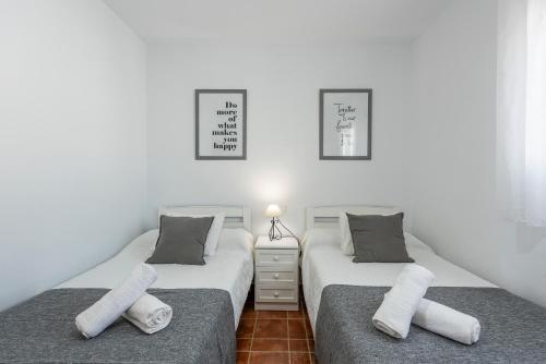 2 Einzelbetten in einem Zimmer mit weißen Wänden in der Unterkunft Cortijo Las Vistas in Cómpeta