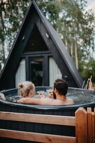a man and a woman sitting in a hot tub at MiLight in Aucugals