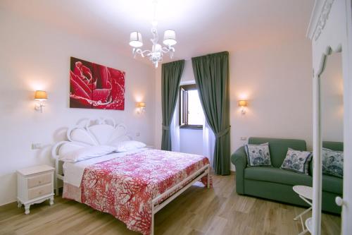 a bedroom with a bed and a green couch at Villa Rosa Francesca in Acciaroli