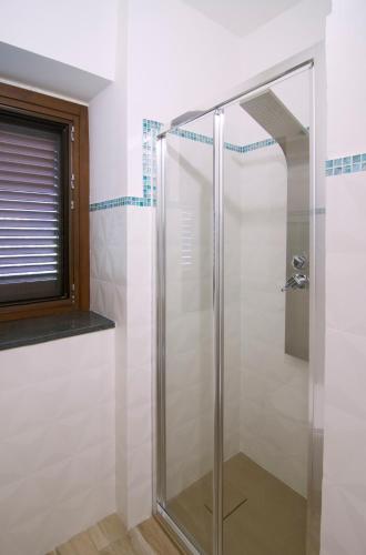 a shower with a glass door in a bathroom at Villa Rosa Francesca in Acciaroli