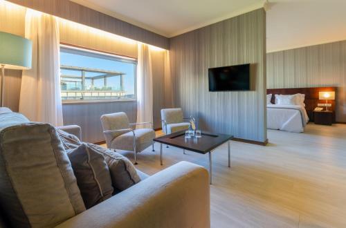 a hotel room with a couch and a bed at Olissippo Oriente in Lisbon