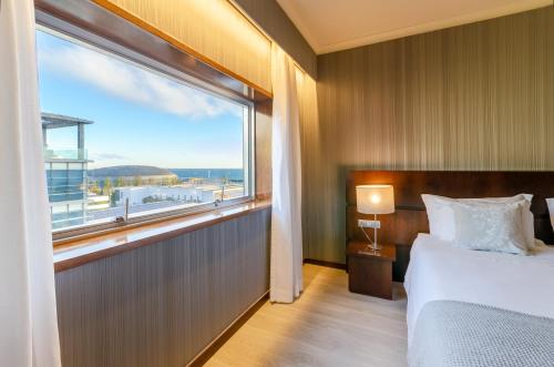 a bedroom with a bed and a large window at Olissippo Oriente in Lisbon