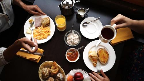 una mesa cubierta con platos de desayuno y café en Hôtel Real Nyon by HappyCulture en Nyon