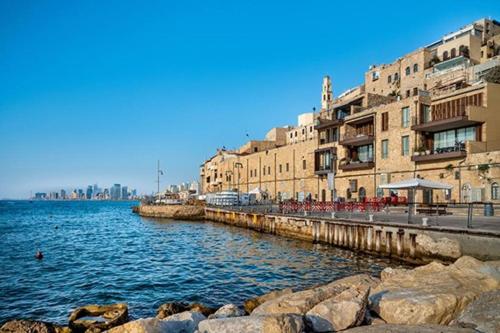 a body of water next to some buildings and some rocks at Central, Authentic and Stylish Old Yafo Experience in Tel Aviv
