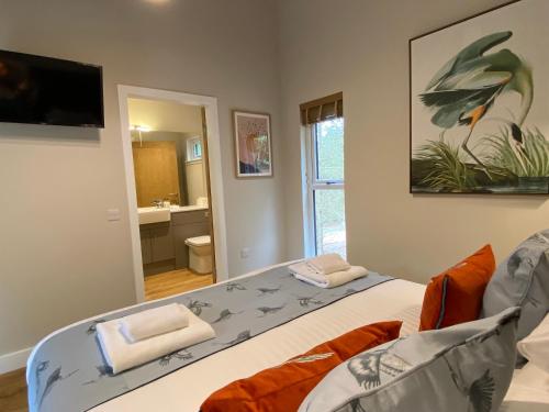 a bedroom with a bed and a tv and a bathroom at Conker Lodge with Hot Tub in Cupar