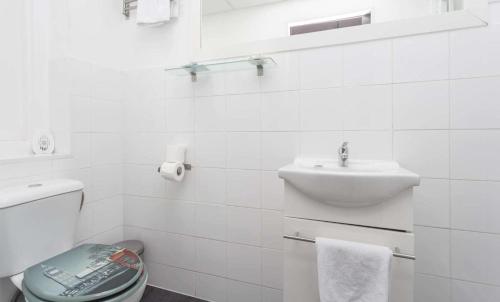 a white bathroom with a sink and a toilet at Desing Puerta del Sol 6 in Madrid