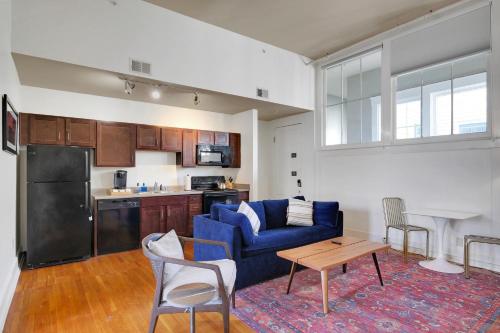 a living room with a blue couch and a kitchen at Historic Charm In Guthrie Coke Lofts in Louisville