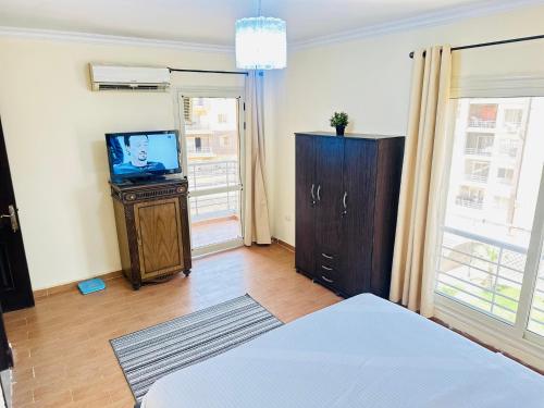Una habitación con TV y una cama en una habitación en Casa Do Cairo - Dar Masr AlRehab Kappa, en El Cairo