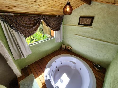 - des toilettes blanches dans une chambre avec fenêtre dans l'établissement Sitio Vale Piemonte "Chalés ", à Santo Antônio do Pinhal