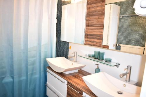 ein Badezimmer mit 2 Waschbecken und einem Spiegel in der Unterkunft Rhodania A 3003 Kl in Lenzerheide