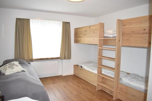 ein Schlafzimmer mit einem Etagenbett und einer Leiter in der Unterkunft Rhodania A 3003 Kl in Lenzerheide