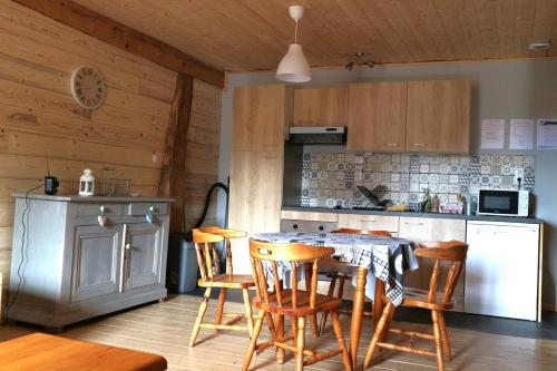 Charmant Gite 4 Places dans le Jura في Marigny: مطبخ مع طاولة وكراسي في غرفة