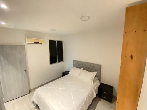 een slaapkamer met een wit bed en een raam bij Apartamento santa marta LE’More in Santa Marta