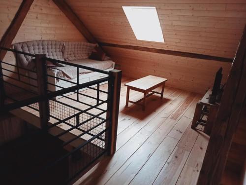 a room with a bed and a table in a attic at Charmant Gite 6 Places Secteur Jura in Marigny