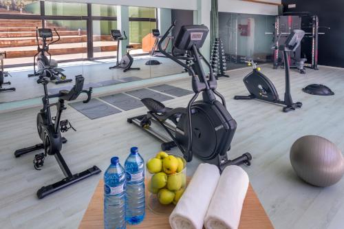 a gym with exercise bikes and water bottles on the floor at Hotel & Resort Vilar Rural d'Arnes by Serhs Hotels in Arnés