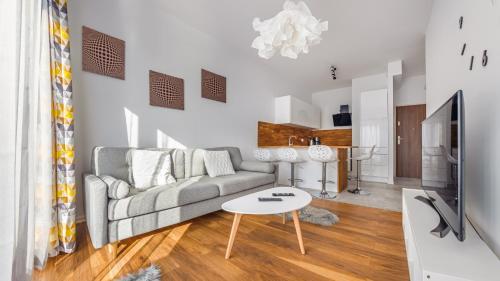 a living room with a couch and a table at City Center SPA Apartments Jaglana 6A with Parking in Gdańsk