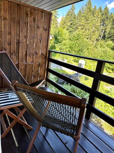 a rocking chair sitting on a deck with a view at Forest Apart in Predeal