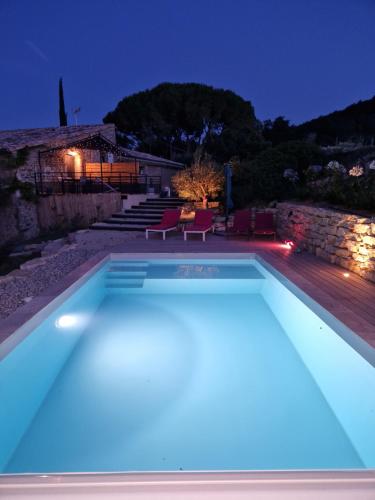 a swimming pool lit up at night at Gite de charme La Martinelle in La Bégude-de-Mazenc