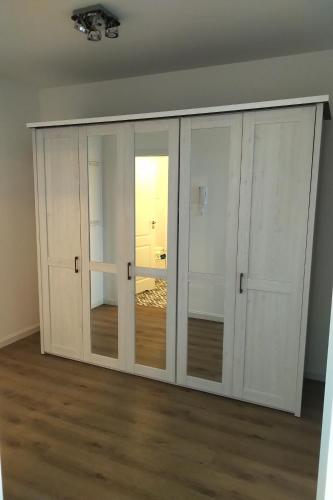 a white closet with glass doors in a room at Nowy w centrum 2 in Giżycko