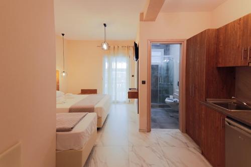 a hotel room with two beds and a bathroom at ELYSIUM - villa majken in Olympiaki Akti