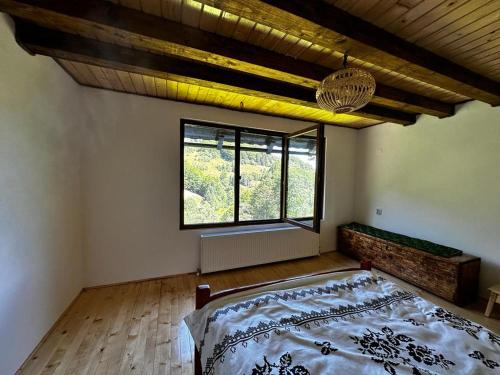 a bedroom with a bed and a large window at Casa Sufletului in Avram Iancu
