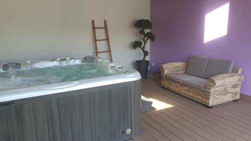 - un salon avec une grande baignoire et une chaise dans l'établissement Hotel Eskualduna Chez Katina, à Saint-Martin-dʼArrossa