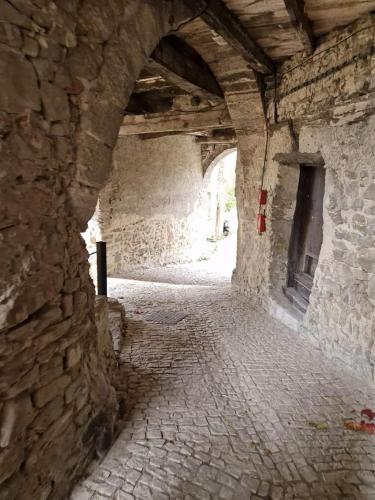 a stone hallway with an archway in a building at Gite de charme La Martinelle in La Bégude-de-Mazenc