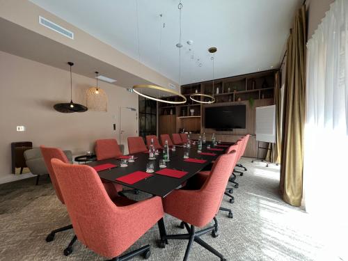 a conference room with a long table and red chairs at Maison Rouge Strasbourg Hotel & Spa, Autograph Collection in Strasbourg