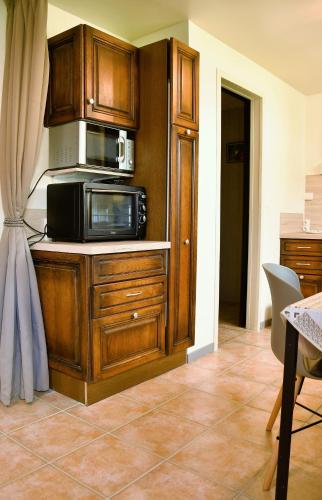 a kitchen with a microwave on a wooden cabinet at AU LOGIS DES CHOUETTES, proche de Verdun et ses champs de bataille in Châtillon-sous-les-Côtes