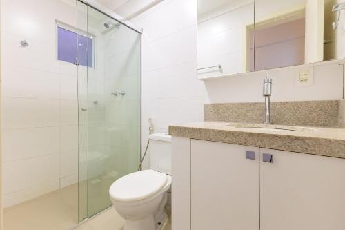 a bathroom with a toilet and a glass shower at Excelente Cobertura, Pra Quem Gosta de Conforto e Alto Padrão - 3 dorms - 7 pessoas in Bombinhas