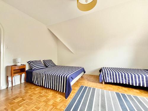 プロネヴェ・ポルゼにあるLA VILLA STE ANNE - Wifi - Plages et bourg de Plonevez à 2 minのベッド2台とテーブルが備わる客室です。