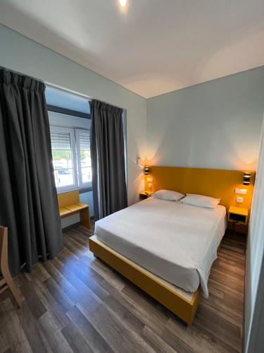 a bedroom with a large bed and two windows at Fonte Luminosa in Lisbon